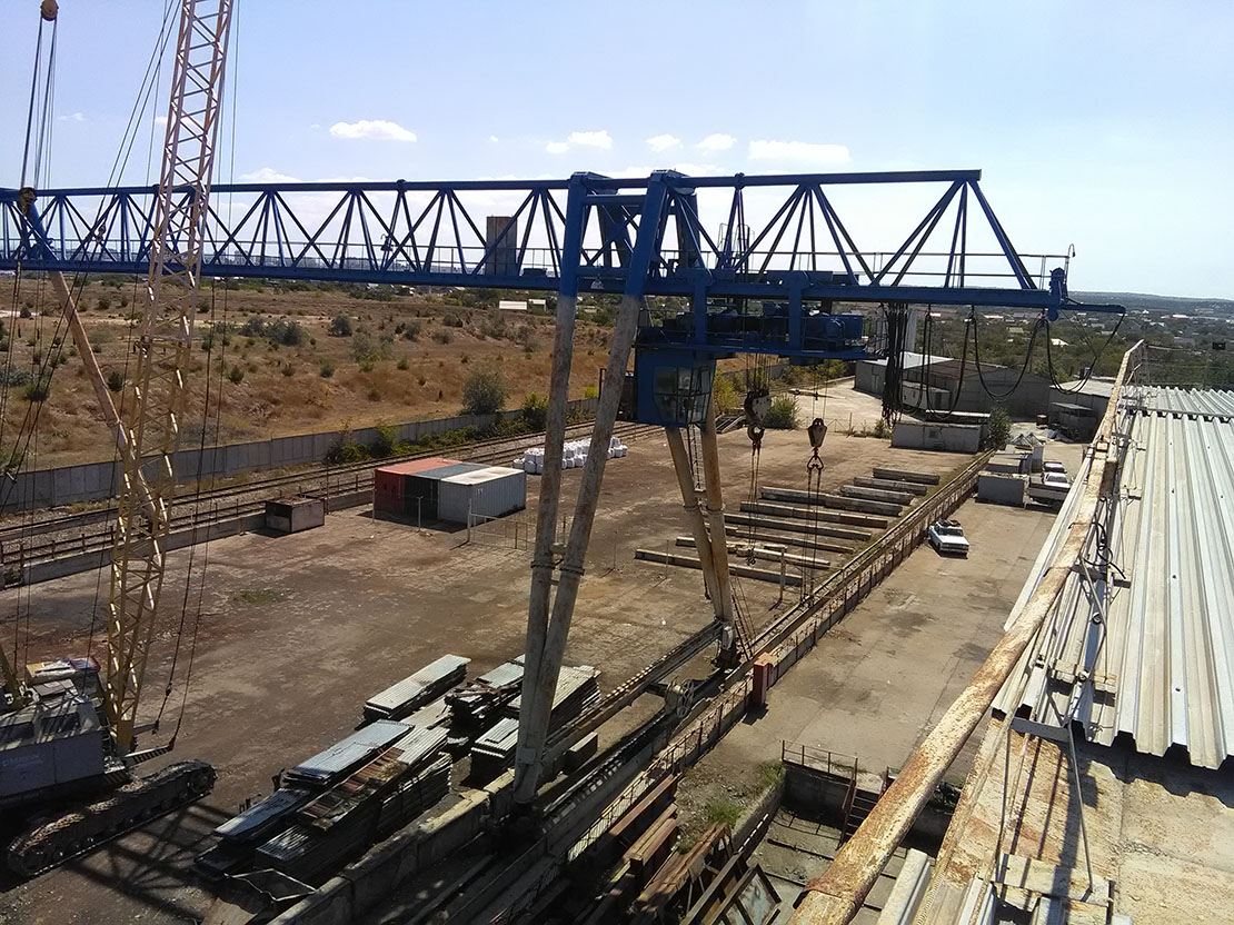 площадка козловым краном. козловой кран балткран. двухконсольный козловой кран. кран козловой пролет 40 метров. козловой кран на белом фоне.